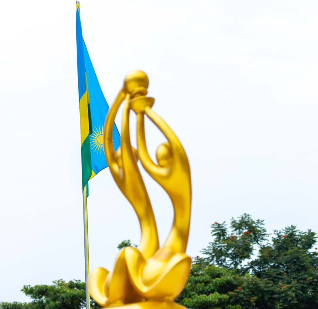 Rwandan national flag with a golden unity sculpture