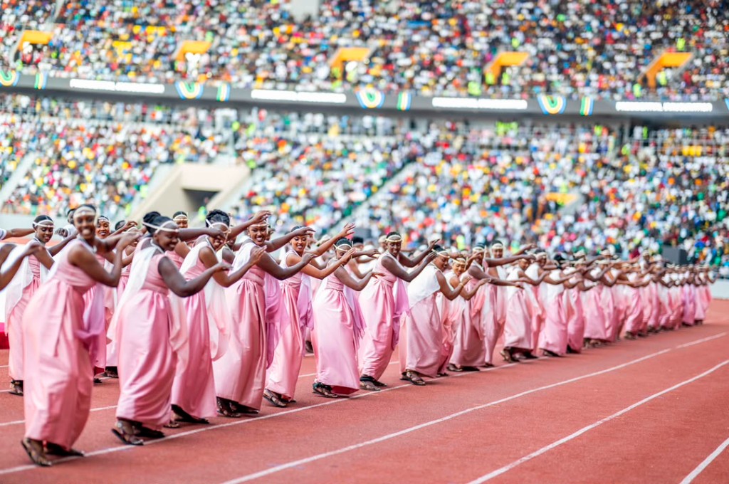 Women in pink umushanana dancing at a stadium inauguration event