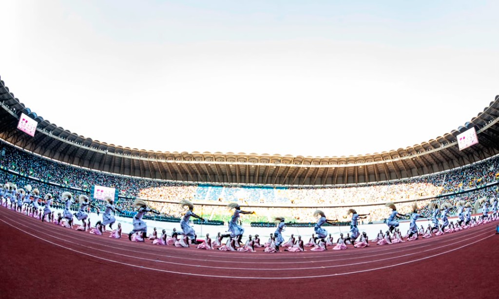 Wide stadium view of Intore dancers and cultural performers